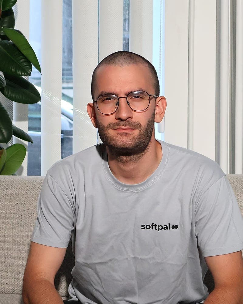 Burak Cecebi, Chief Financial Officer von softpal, sitzend vor einer hellen Fensterfront